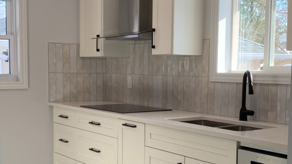 A newly renovated white kitchen with black hardware throughout.